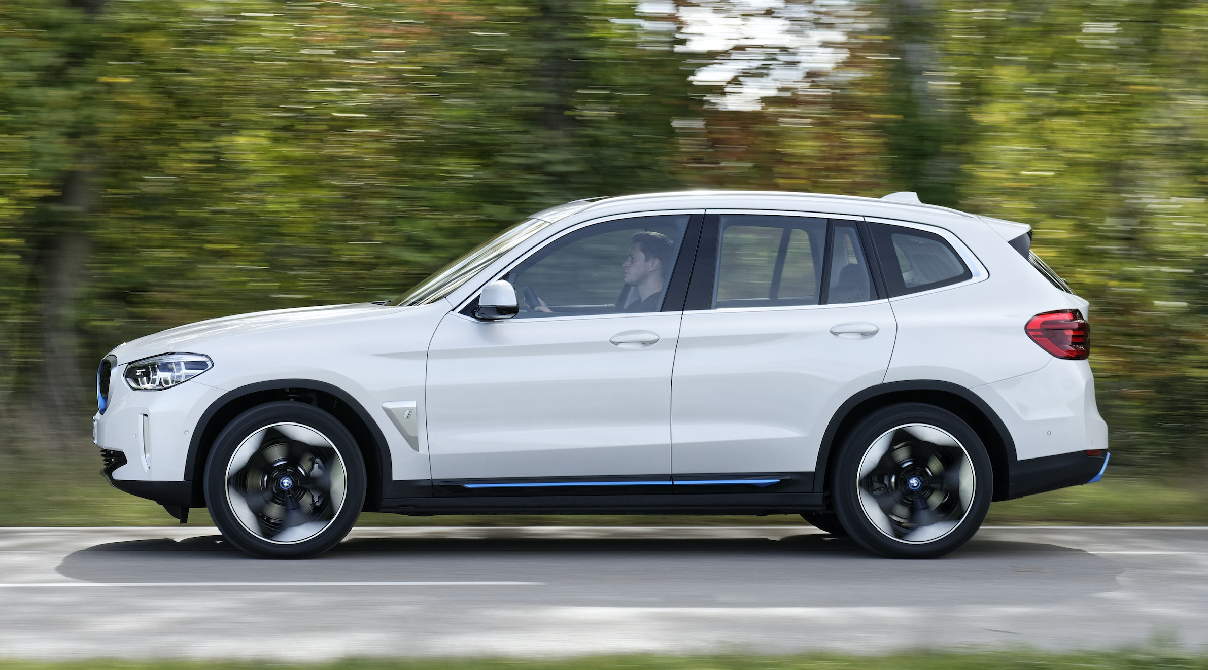 BMW iX3 exterior side driving in country