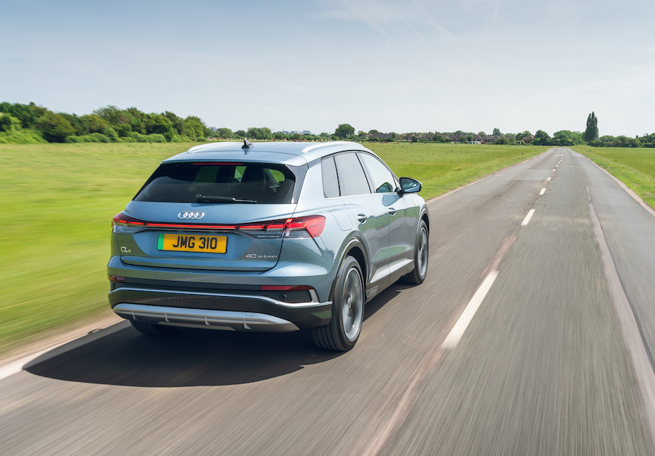 Audi Q4 e-tron rear action shot, straight road in countryside, blue/silver car, RHD, UK plates