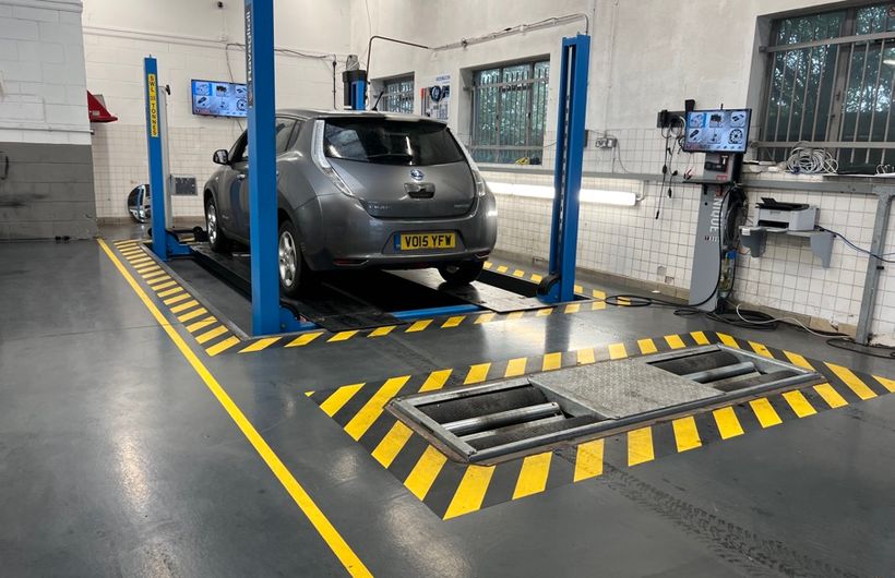 Grey 2015 Nissan Leaf in MoT test bay on ramps