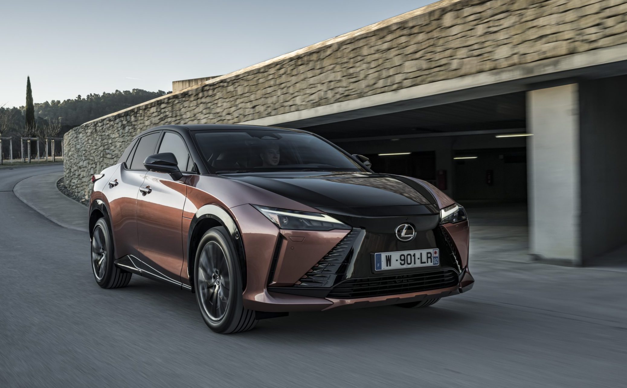 Lexus RZ 450e, front action by building, two tone copper/black, French registration